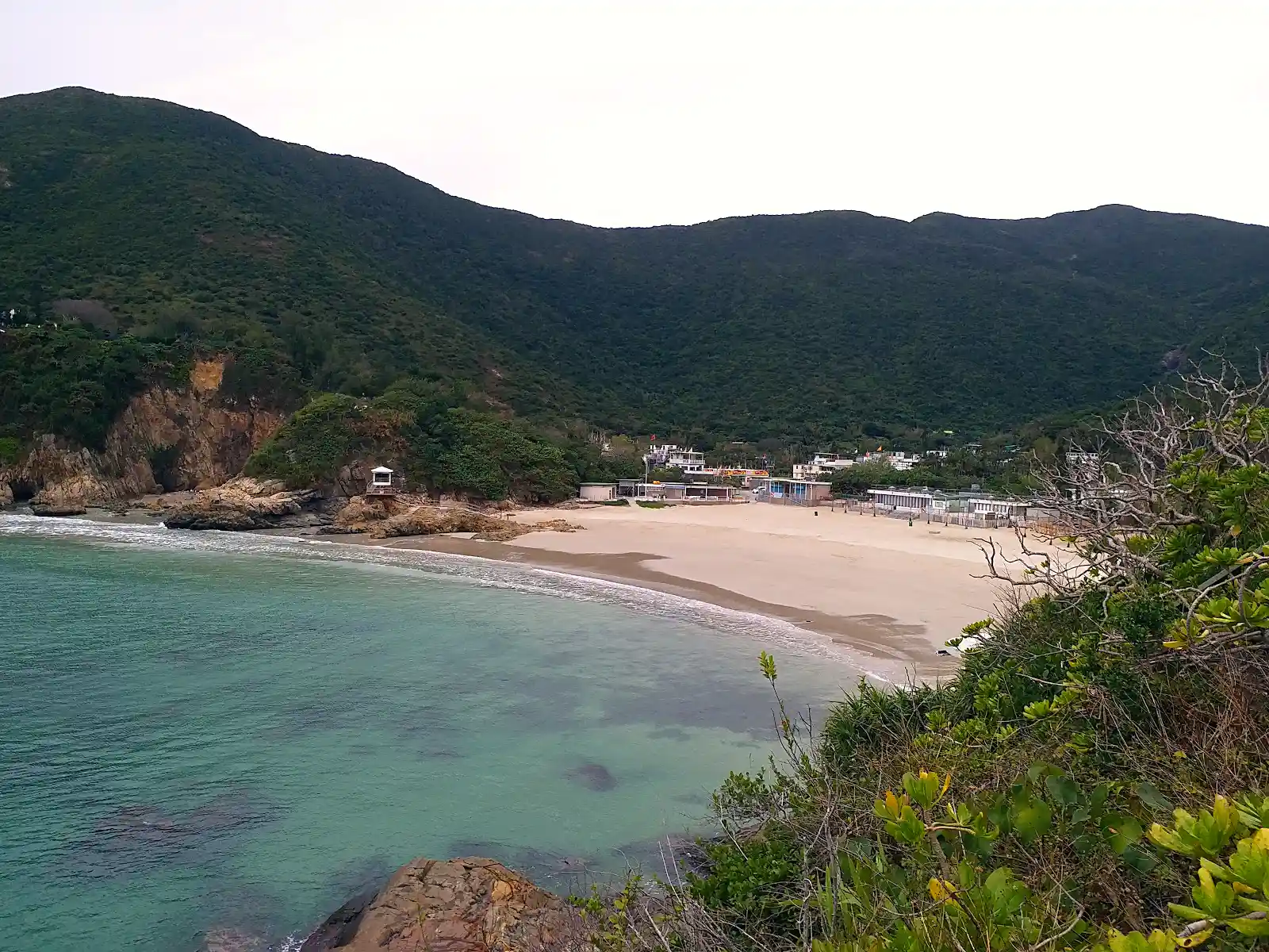 Surfers and quiet sand at Big Wave Bay on Hong Kong Island's east side