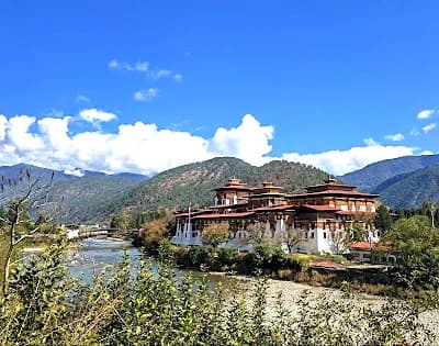 Punakha Dzong at the river confluence in Bhutan surrounded by green mountain valley