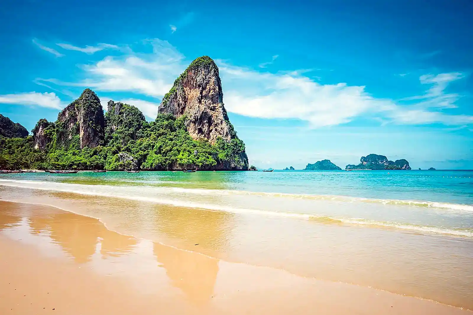 Railay beach limestone cliffs and longtail boats on Thailand's Andaman coast