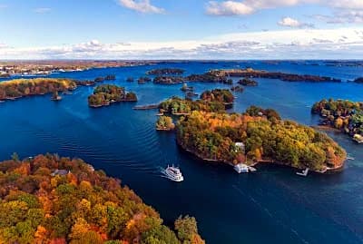 Small forested islands scattered along the Thousand Islands river channel near Kingston