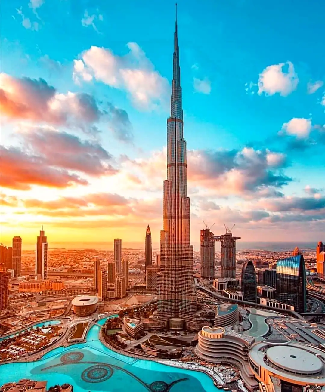 Burj Khalifa tower soaring above Downtown Dubai skyline at dusk on a clear evening