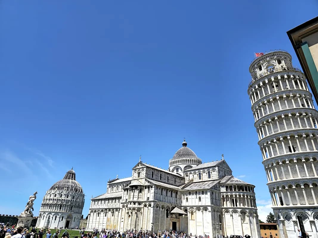 The Leaning Tower of Pisa standing beside the cathedral in morning light
