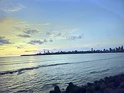 travellers walking along Marine Drive in Mumbai India at dusk