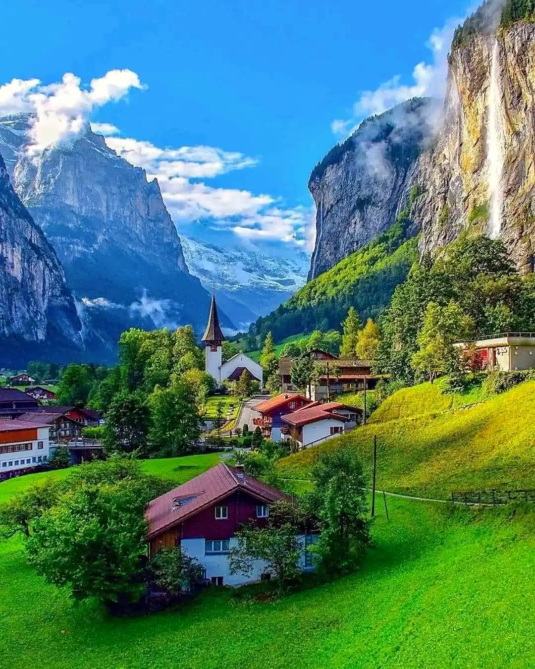 Snow-capped Swiss Alps with dramatic mountain peaks and a green valley in Switzerland