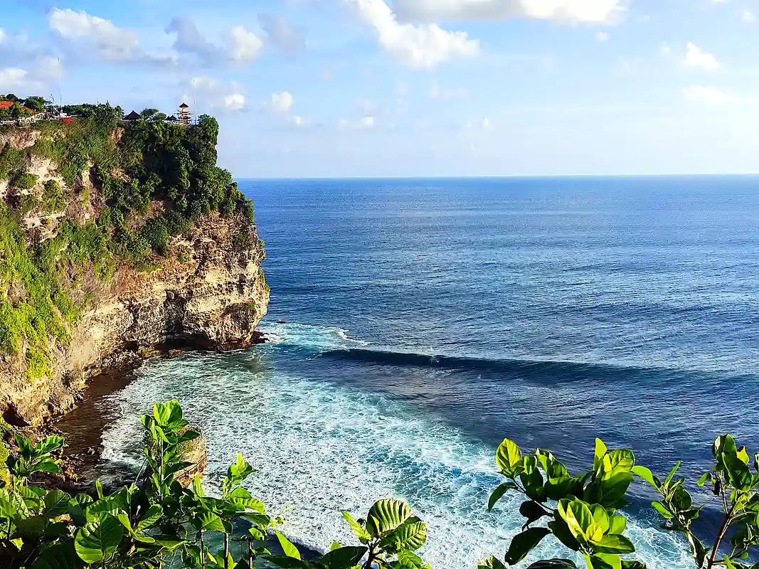 Cliffside Uluwatu temple in Bali overlooking the ocean at sunset