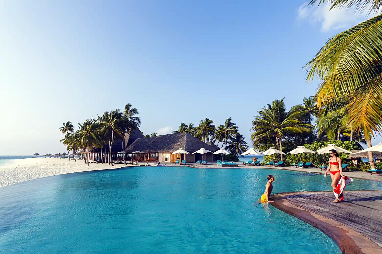 Veligandu island in the Maldives showing turquoise lagoon and white sand beach from the shore